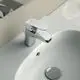 Waschtischarmatur von Ideal Standard mit einem glatten Chrom-Finishing, bedienbar über einen langen Hebel und montiert auf einem weißen Waschbecken.